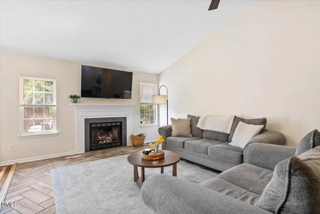 a living room with furniture a flat screen tv and a fireplace