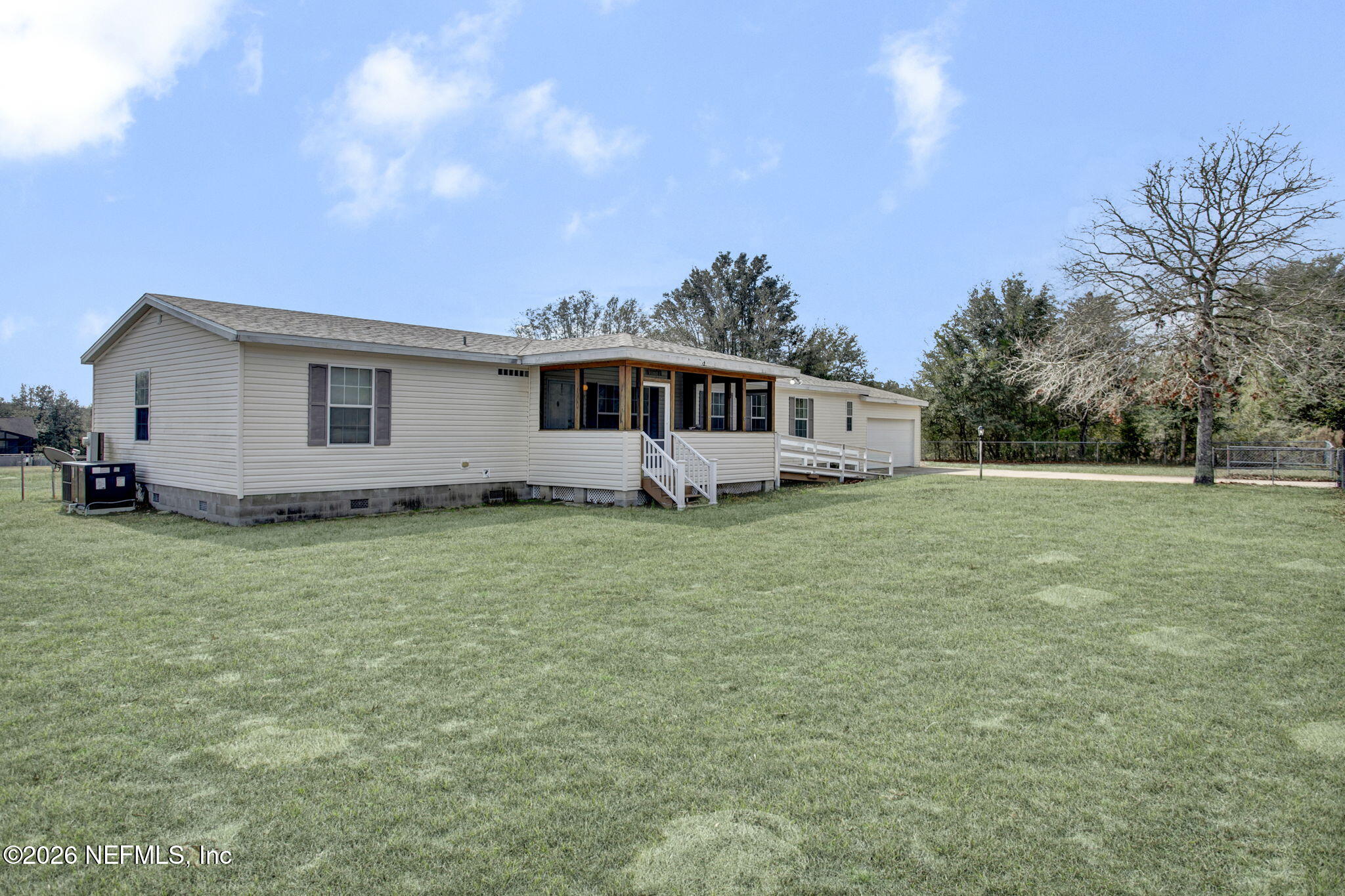 a front view of house with yard and trees in the background
