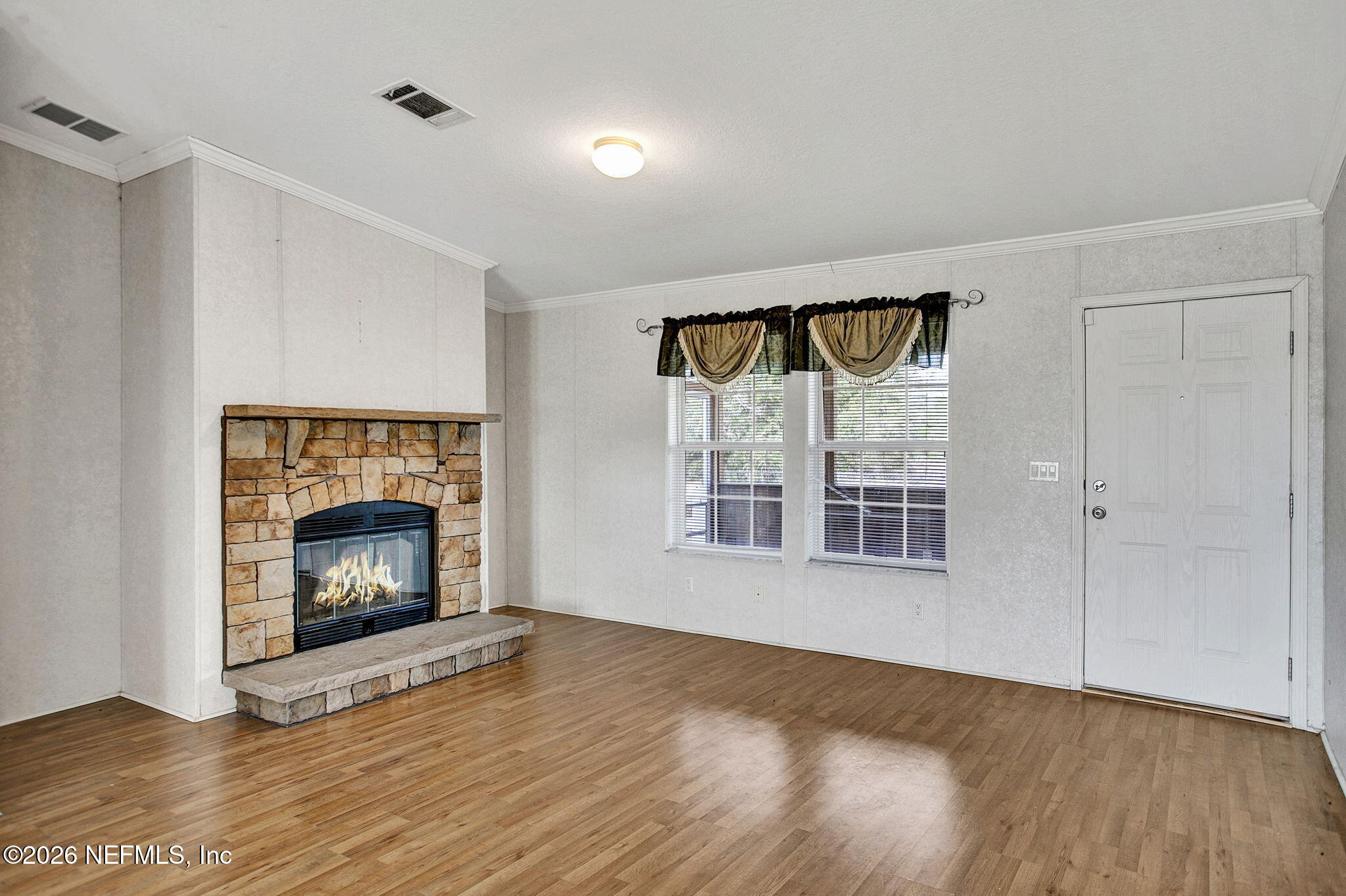 5891 Sequoia Road Keystone Heights, FL 32656 - Photo 2 of 29 a view of an empty room with wooden floor fireplace and a window