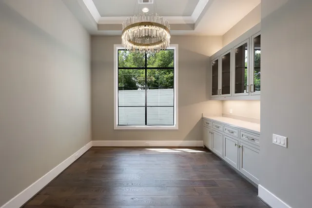 a view of an empty room with wooden floor and a fireplace