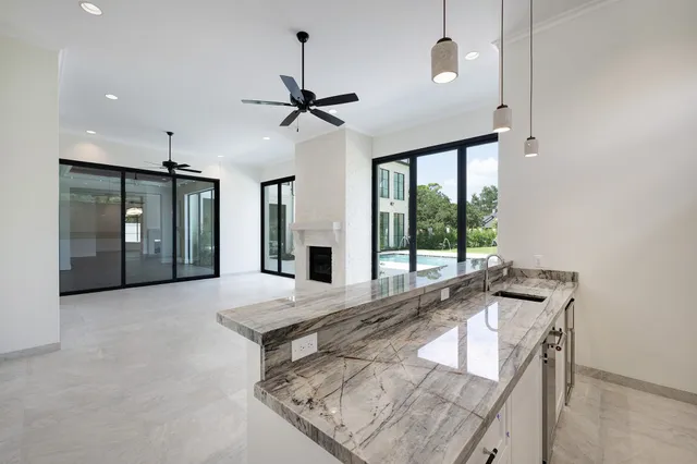 a kitchen with granite countertop white cabinets and a sink