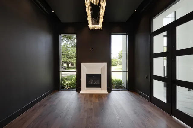 an empty room with wooden floor and a fireplace