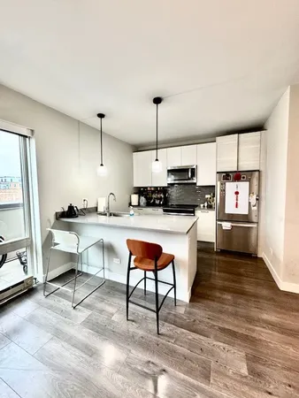 a kitchen with stainless steel appliances a sink a stove a refrigerator and cabinets