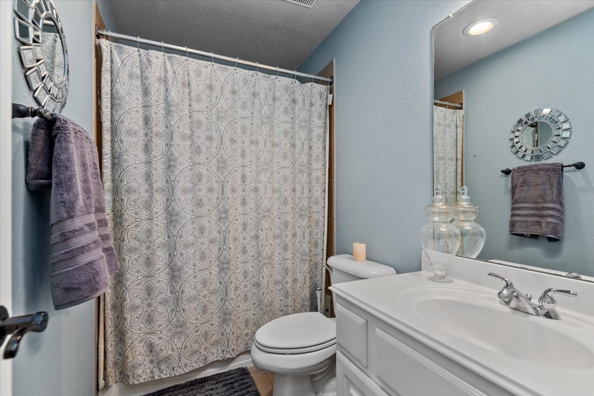 15519 Stallion Point Circle Cypress, TX 77429 - Photo 27 of 37 Bathroom featuring a vanity with a white countertop and sink, a mirror, and a shower with a patterned curtain
