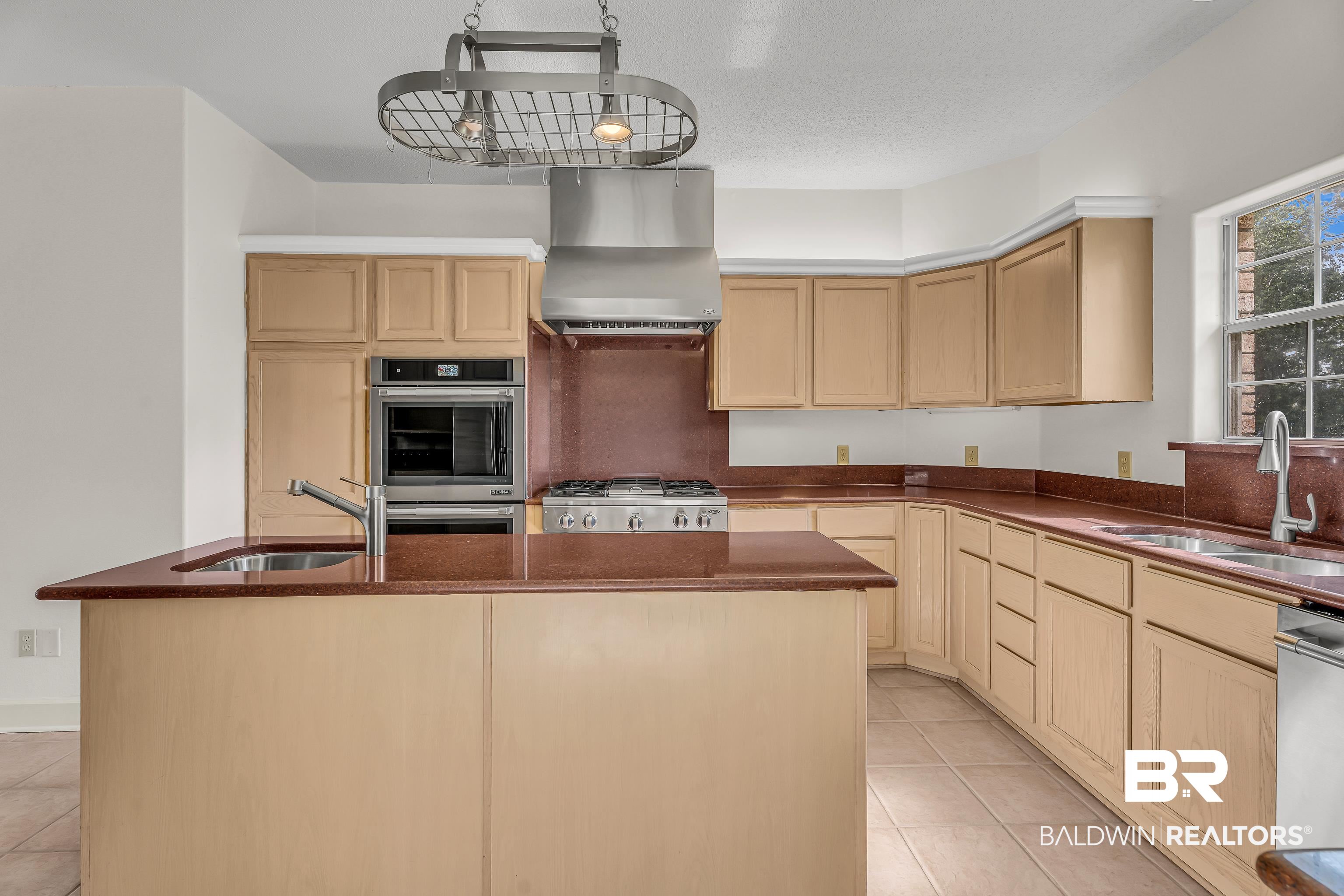 9530 Pilgrim Drive Elberta, AL 36530 - Photo 14 of 61 Kitchen with wall chimney range hood, stainless steel appliances, light tile patterned floors, and a sink