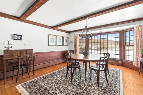 a dining room with furniture a rug and wooden floor