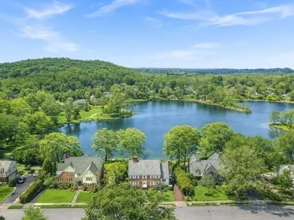 an aerial view of a house with a yard and lake view
