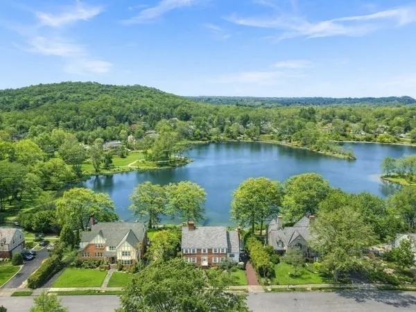 an aerial view of a house with a yard and lake view