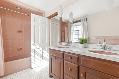 a bathroom with a granite countertop sink and a bathtub