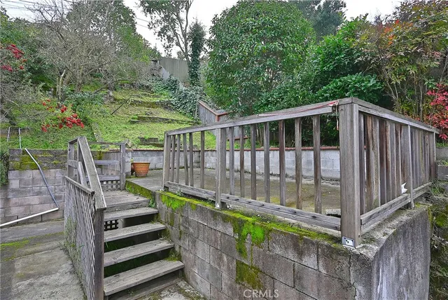 a view of a chair and table in backyard of the house