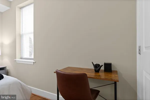 a view of a workspace with furniture and a window
