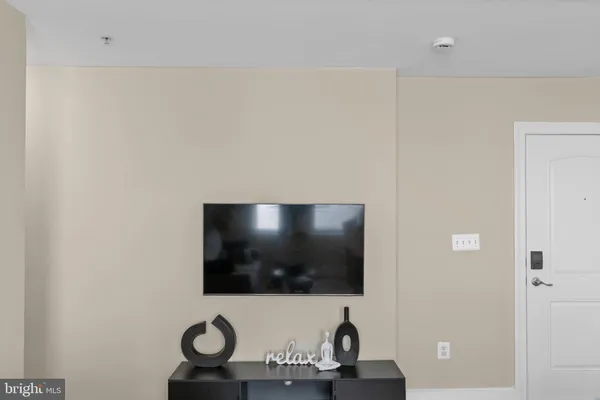 a living room with a flat screen tv and a wall painting