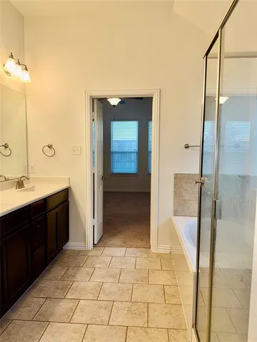 an empty room with a chandelier fan and windows
