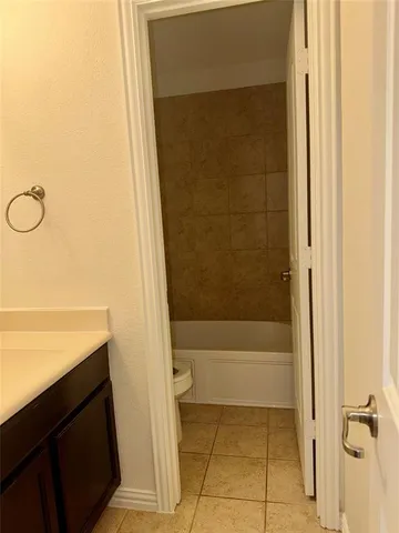 an empty room with a chandelier fan and windows