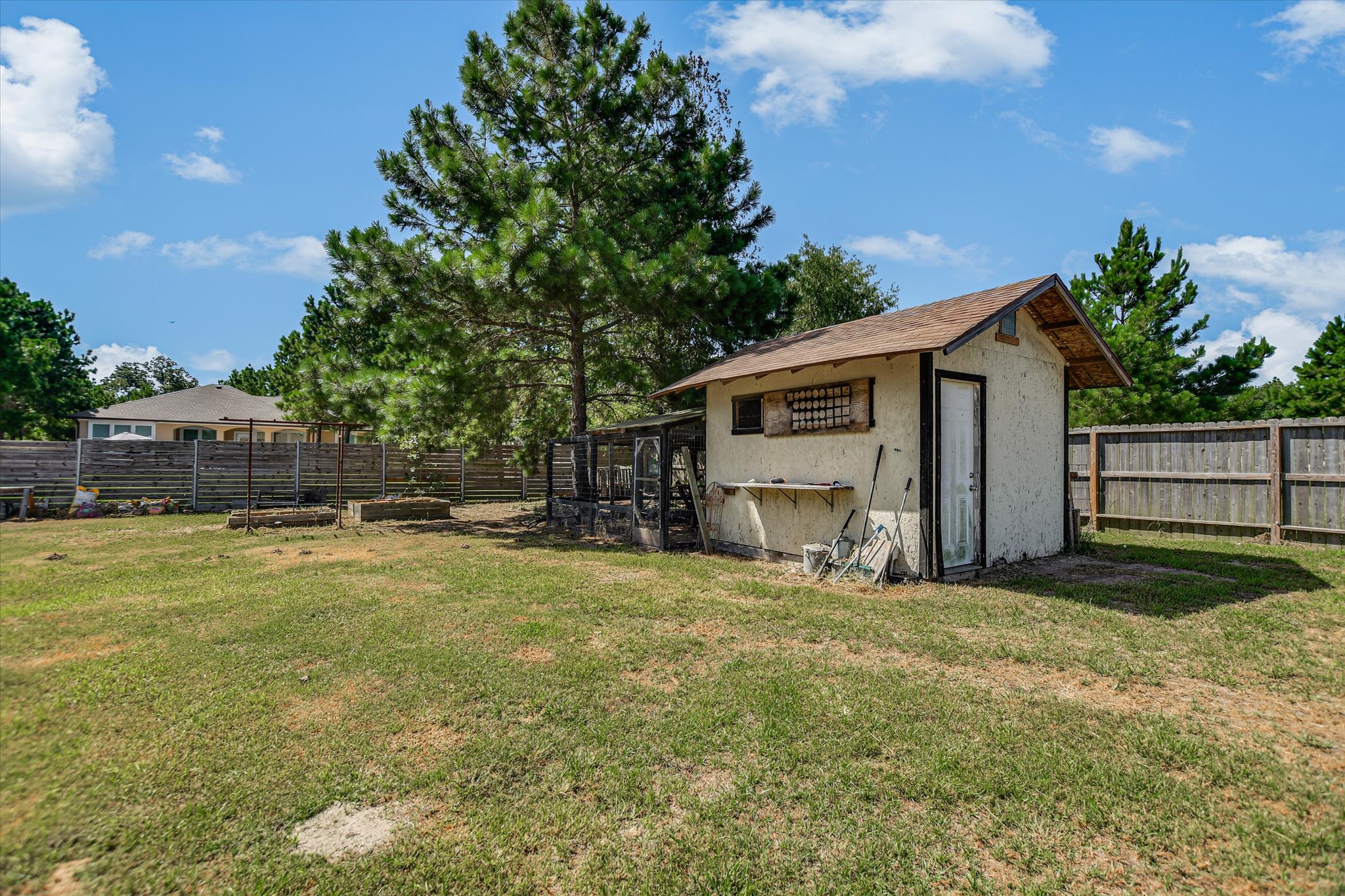 218 Cardinal Loop Paige, TX 78659 - Photo 19 of 22 A quaint outbuilding with an attached enclosure offers versatile utility in this spacious yard.