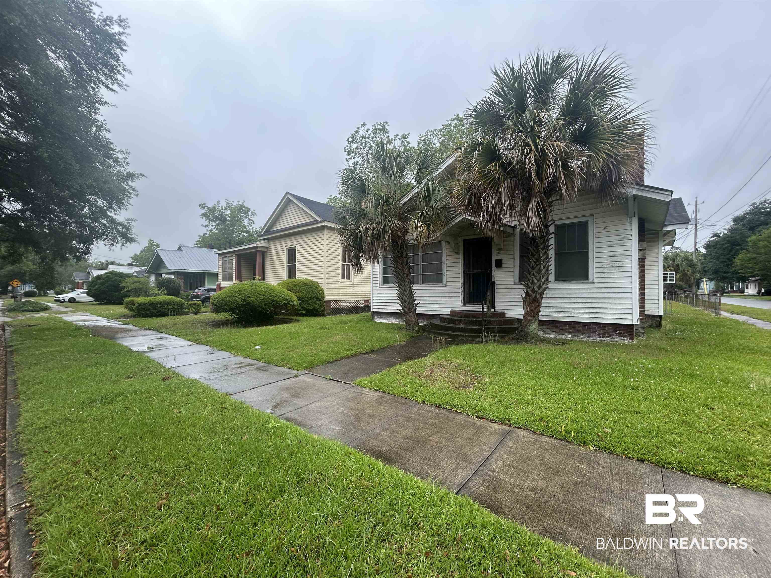 302 Stocking Street Mobile, AL 36604 - Photo 5 of 31 Single-story residence featuring a white siding exterior, dark entry door, and a covered porch with steps