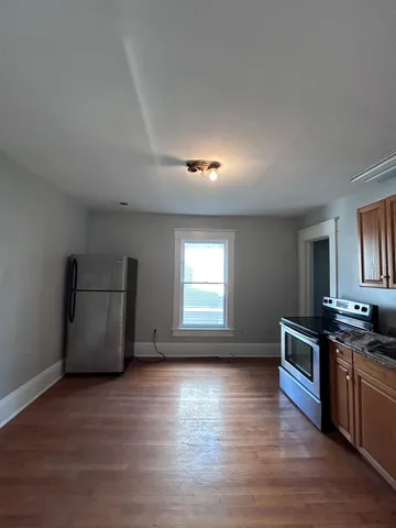 a kitchen with granite countertop a stove and a wooden floors