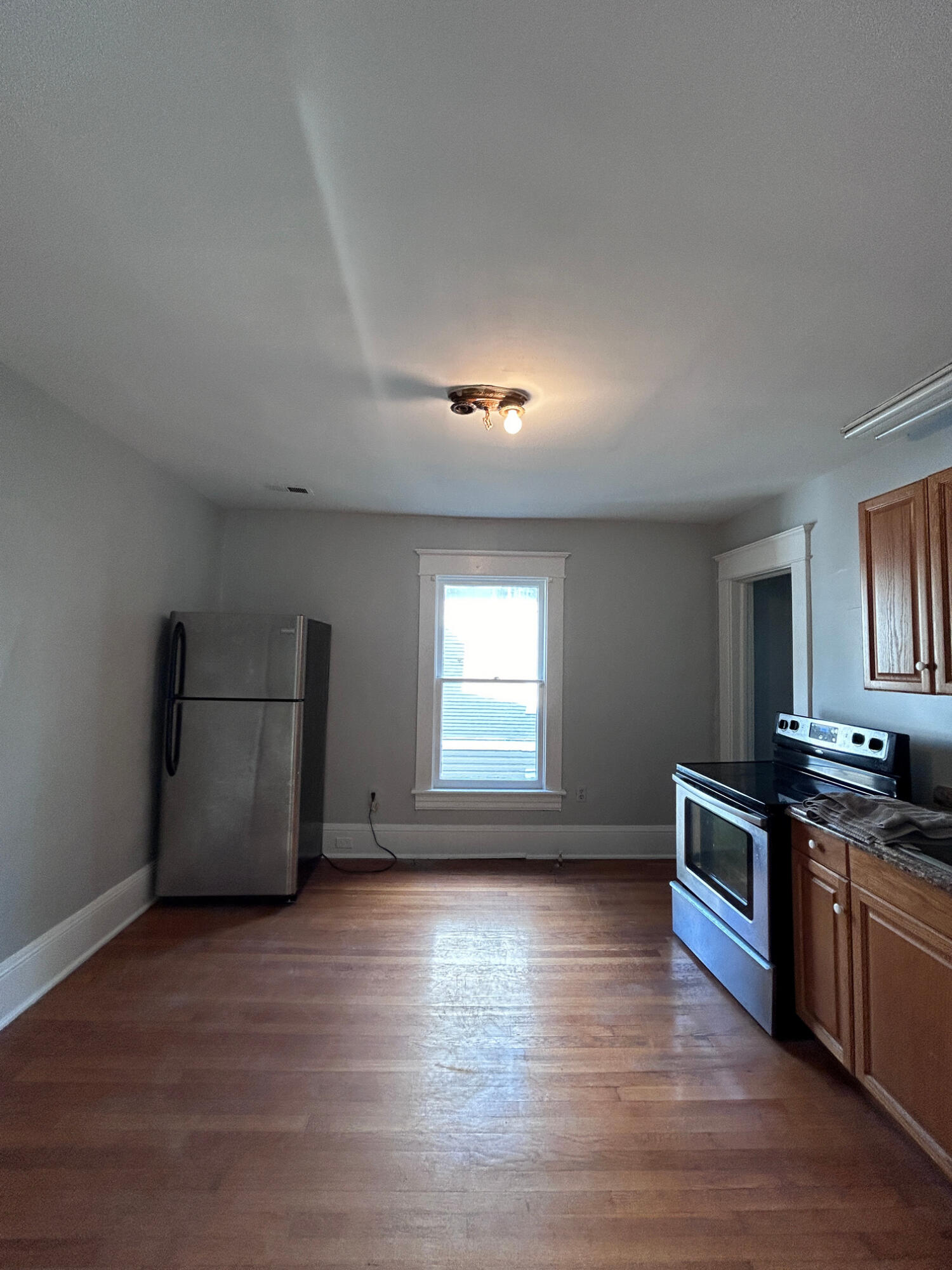 429 Albemarle Avenue Southwest, Unit UPPR Roanoke, VA 24016 - Photo 13 of 24 a kitchen with granite countertop a stove and a wooden floors