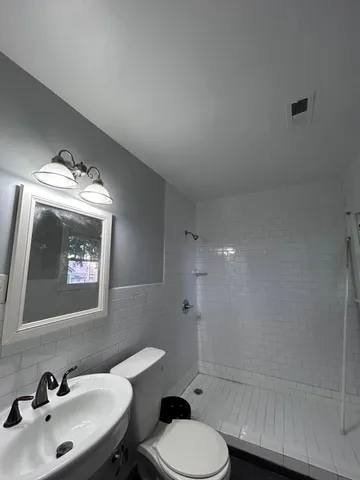 a bathroom with a toilet sink and mirror