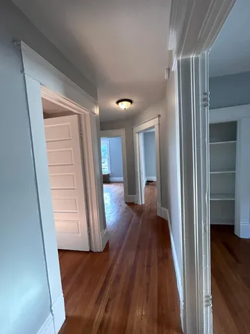 a view of a hallway with wooden floor