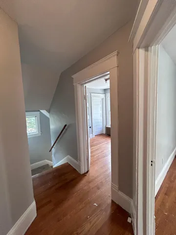 a view of hallway with stairs and wooden floor
