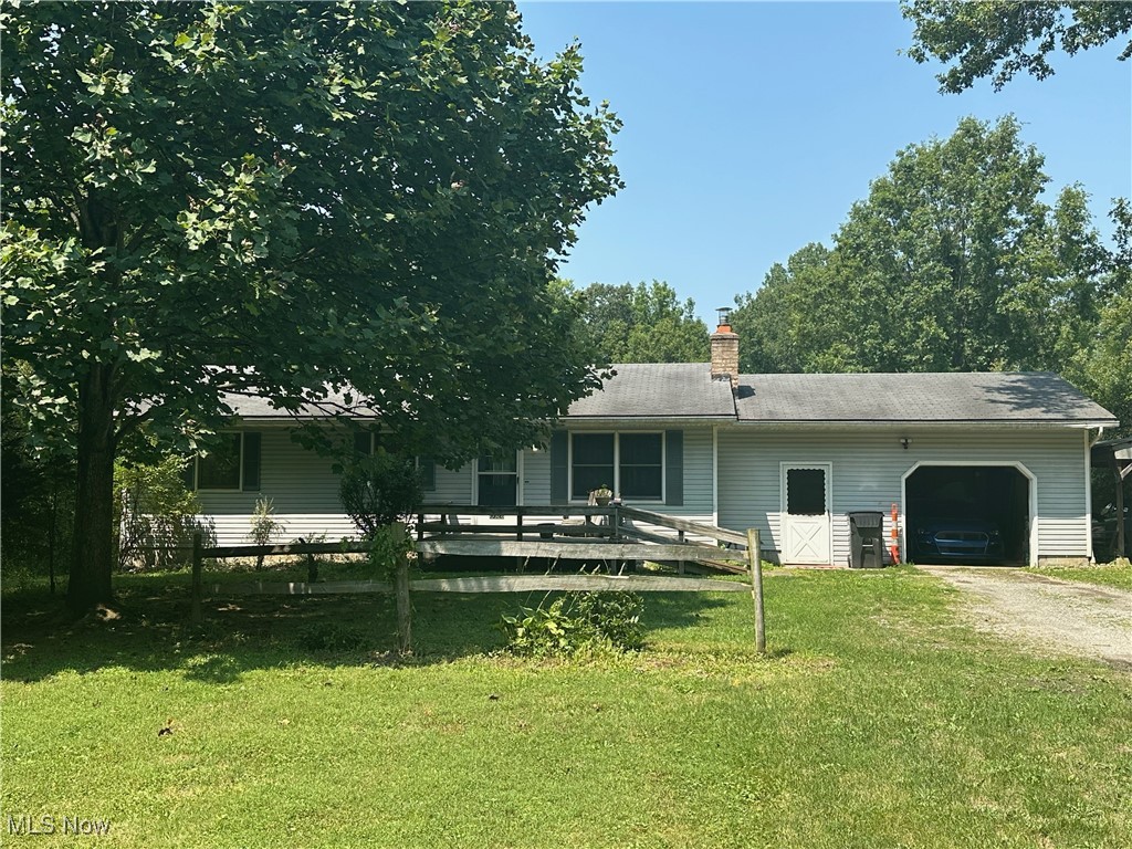  View of property with a garage and a lawn