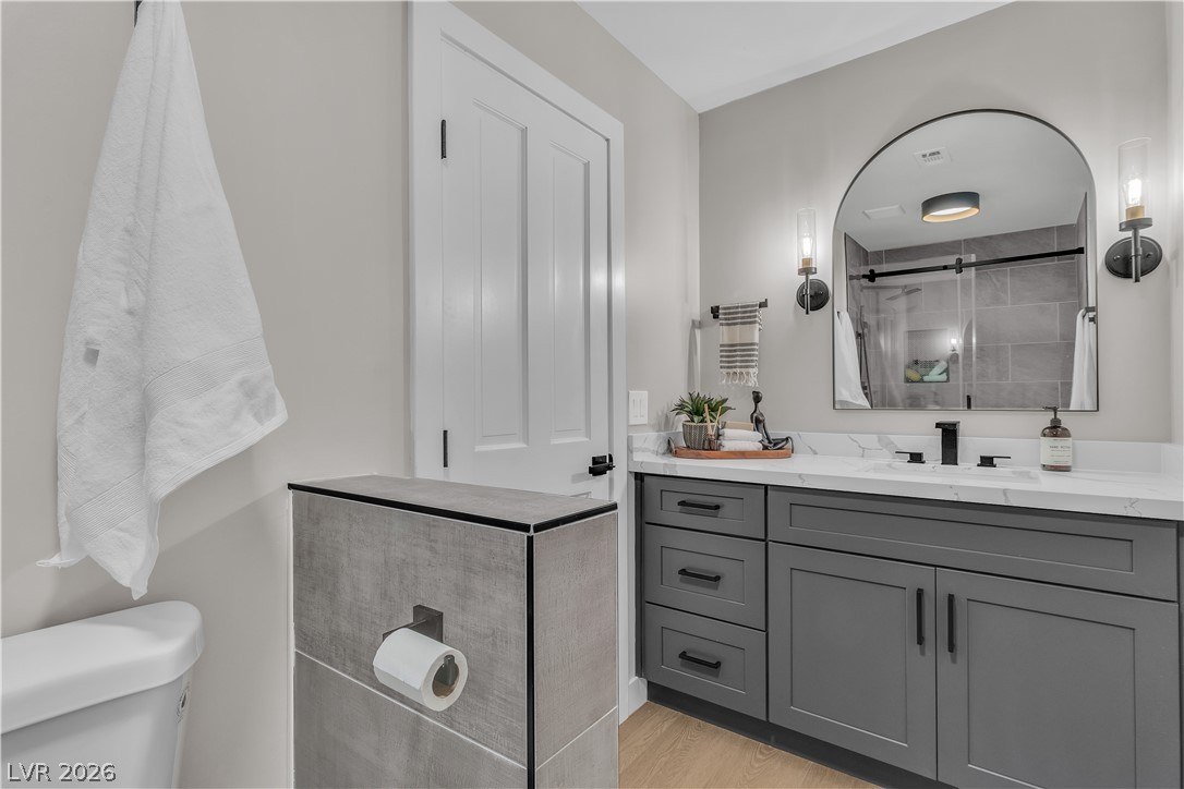 8848 Rainbow Ridge Drive Las Vegas, NV 89117 - Photo 7 of 43 Modern elegance defines this primary bathroom, showcasing a sleek vanity with ample storage and a sophisticated marble countertop.