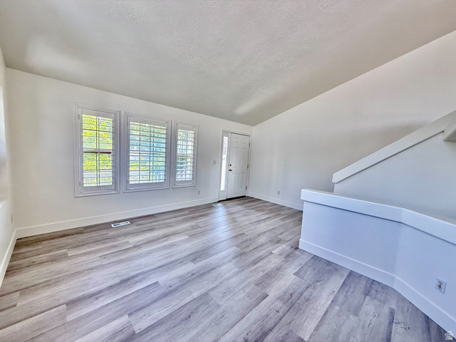 1705 80 East Tooele, UT 84074 - Photo 3 of 22 Spacious interior room featuring light wood-finish flooring, white walls, and bright white trim