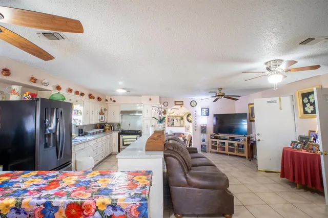 a kitchen with stainless steel appliances kitchen island granite countertop a refrigerator and a sink