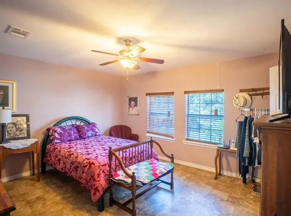 a bedroom with a bed a chandelier and dresser