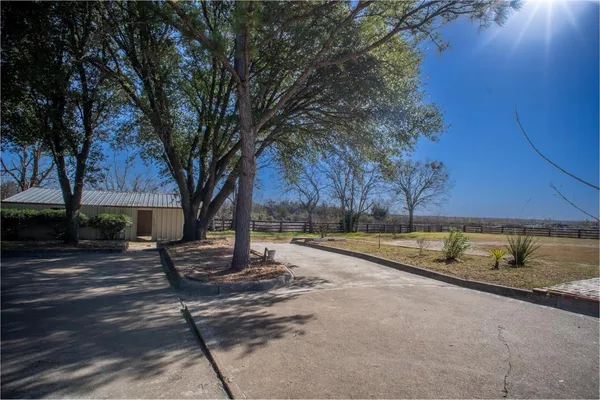 a view of a house with backyard and trees