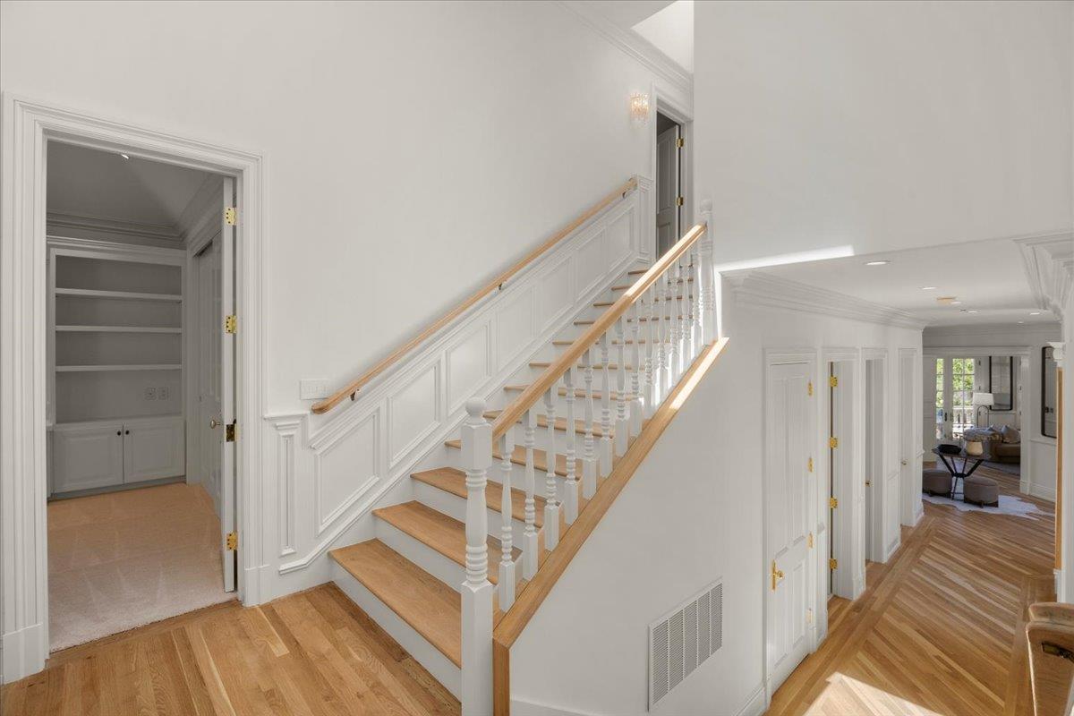14113 Pike Road Saratoga, CA 95070 - Photo 36 of 78 a view of staircase with lots of frames on wall and wooden floor