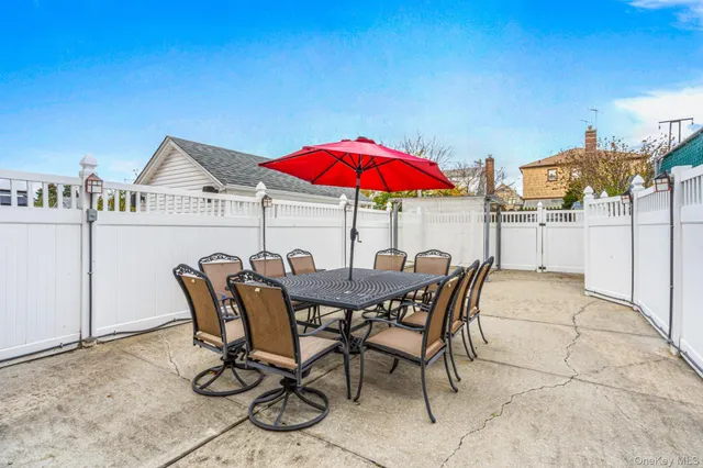 a view of a patio with a table and chairs under an umbrella