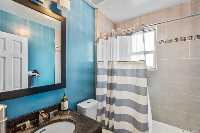 a bathroom with a sink toilet a mirror and shower