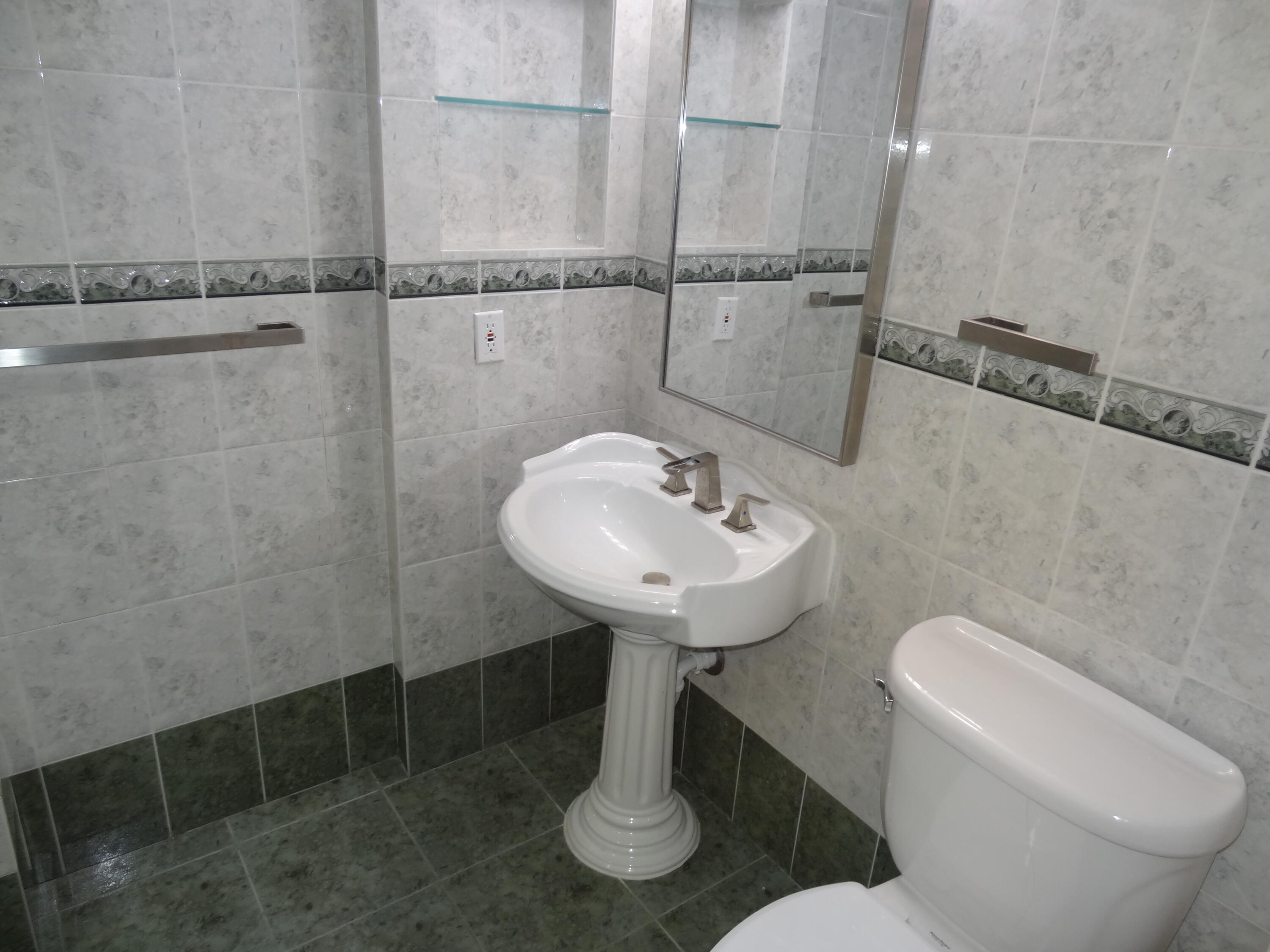 55 Southwest 2nd Avenue, Unit 2090 Boca Raton, FL 33432 - Photo 10 of 12 a bathroom with a sink a toilet and mirror