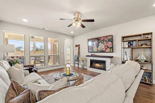 a living room with furniture fireplace and a large window