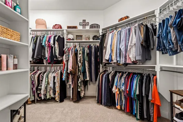 a view of walk in closet with clothes