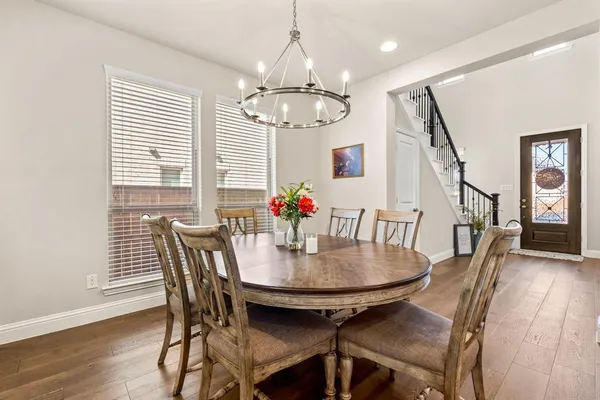 a view of a dining room with furniture wooden floor and chandelier