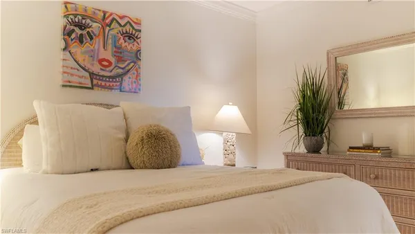 a bedroom with a bed and painting on the wall