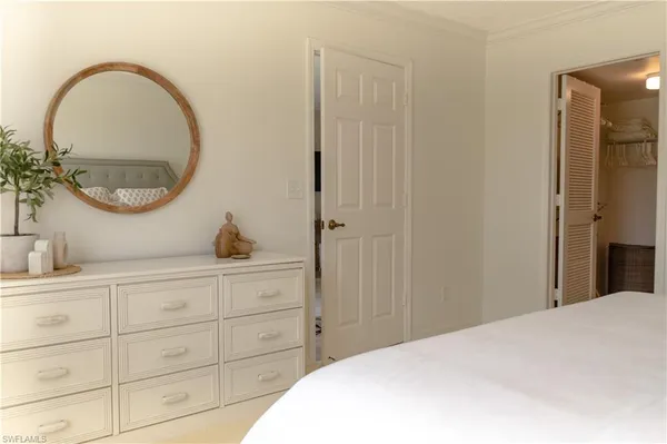a bedroom with a large bed and a night stand