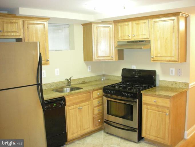 4732 Benning Road Southeast, Unit 102 Washington, DC 20019 - Photo 2 of 28 a kitchen with granite countertop a refrigerator stove and sink