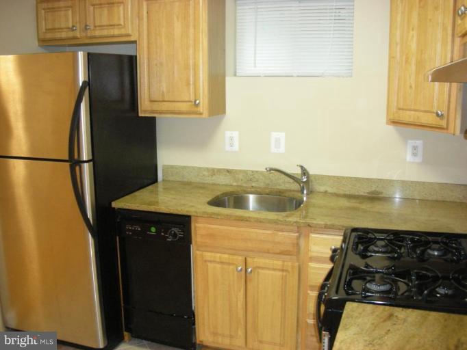 4732 Benning Road Southeast, Unit 102 Washington, DC 20019 - Photo 3 of 28 a kitchen with a refrigerator and a stove