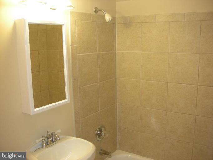 4732 Benning Road Southeast, Unit 102 Washington, DC 20019 - Photo 10 of 28 a bathroom with a sink mirror and toilet