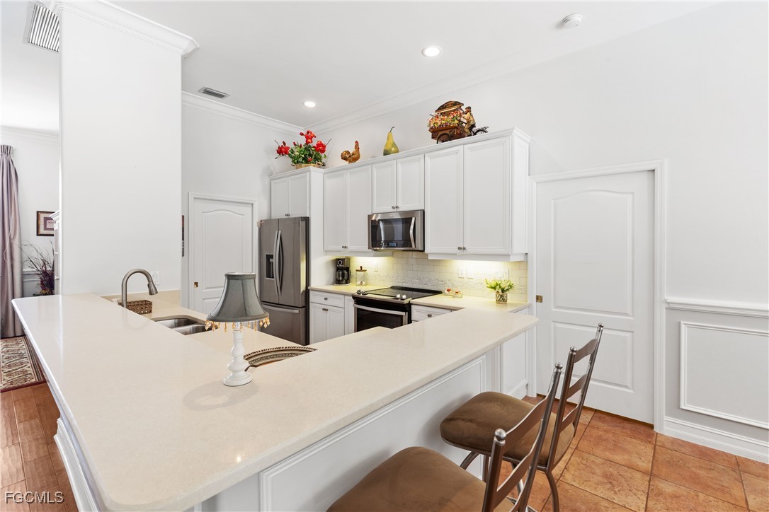 15035 Balmoral Loop Fort Myers, FL 33919 - Photo 18 of 39 a kitchen with a sink a microwave and cabinets