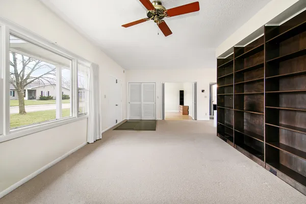a view of empty room with windows and cabinet