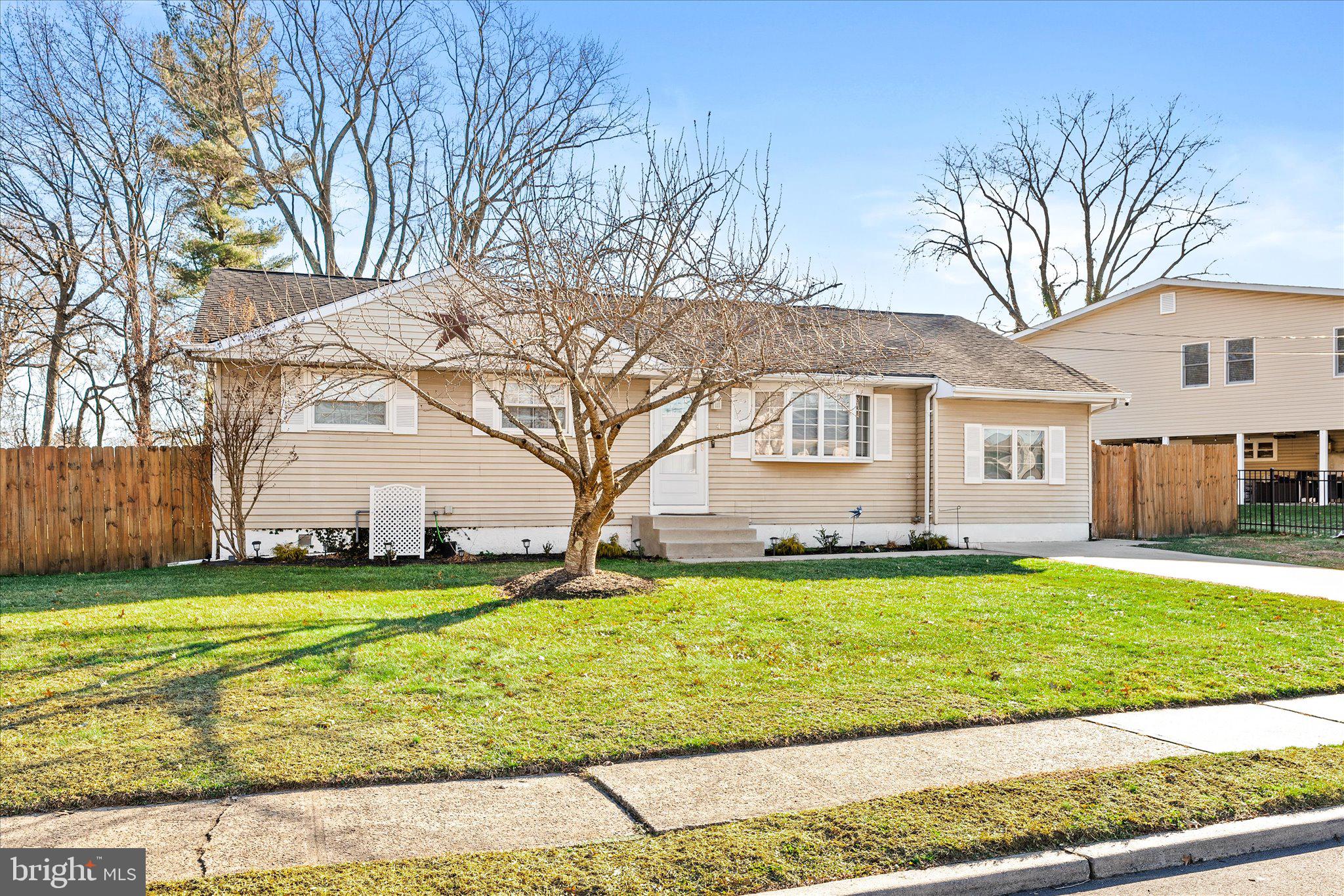 a view of a house with a big yard and large trees