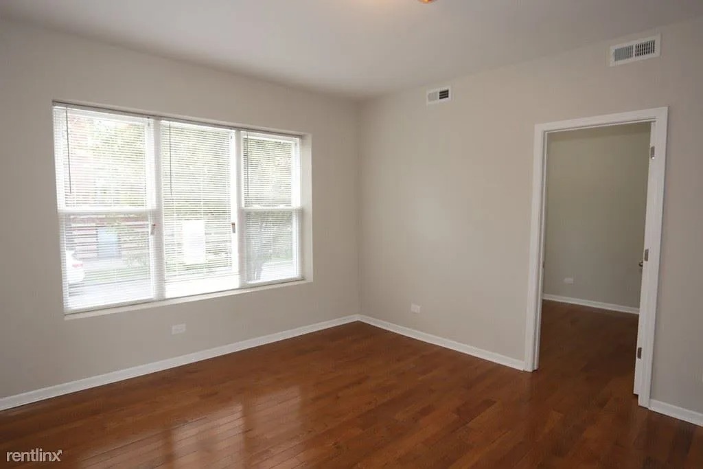 3916 West Altgeld Street, Unit 1 Chicago, IL 60647 - Photo 11 of 18 a view of an empty room with wooden floor and a window