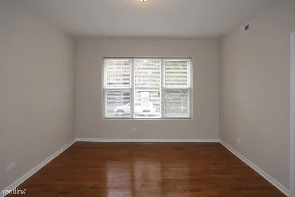 3916 West Altgeld Street, Unit 1 Chicago, IL 60647 - Photo 12 of 18 an empty room with wooden floor and windows