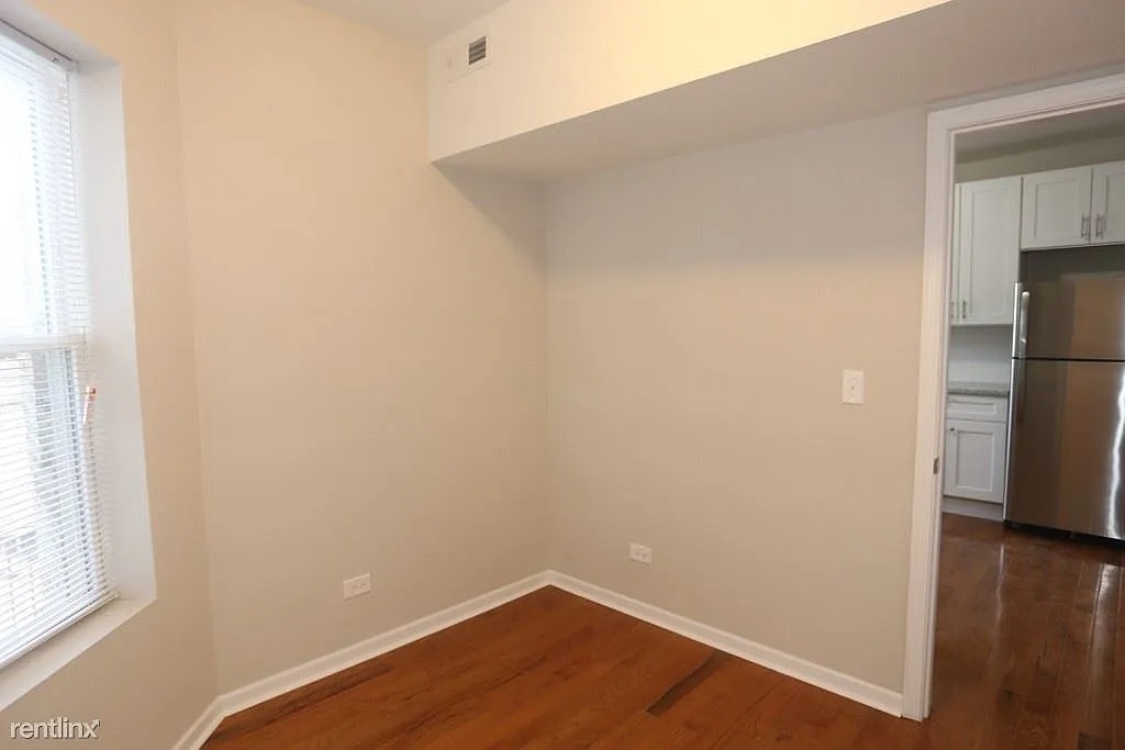 3916 West Altgeld Street, Unit 1 Chicago, IL 60647 - Photo 13 of 18 a view of empty room with wooden floor and window