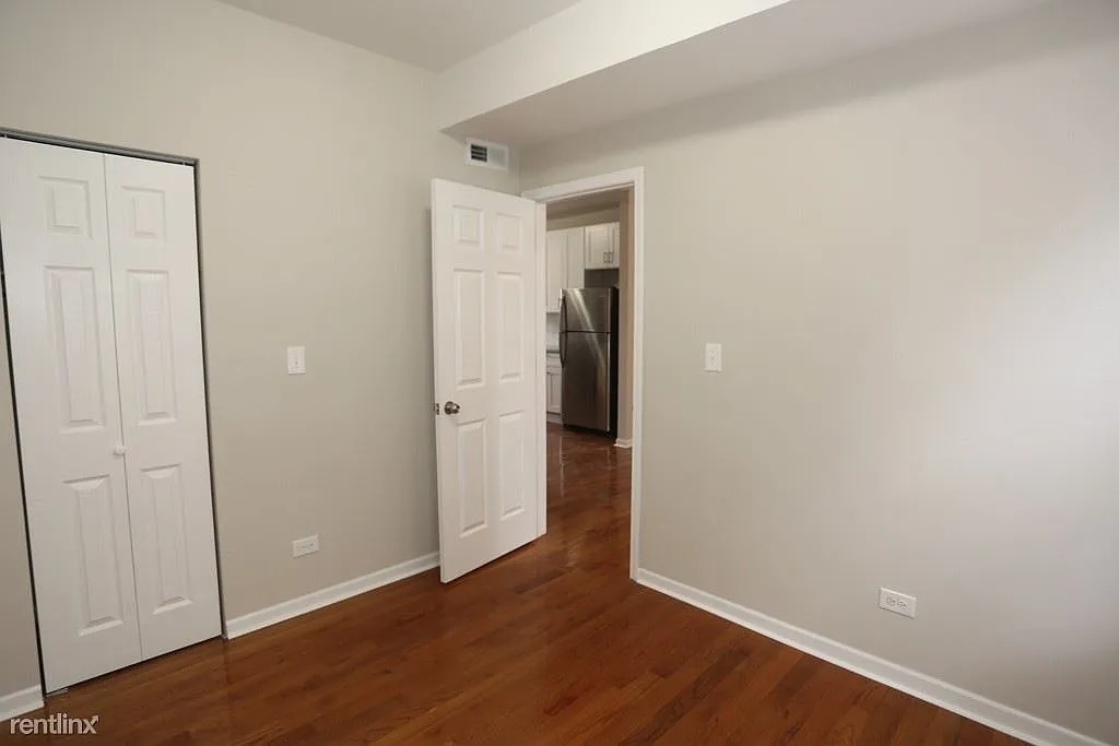 3916 West Altgeld Street, Unit 1 Chicago, IL 60647 - Photo 15 of 18 an empty room with wooden floor & closet area